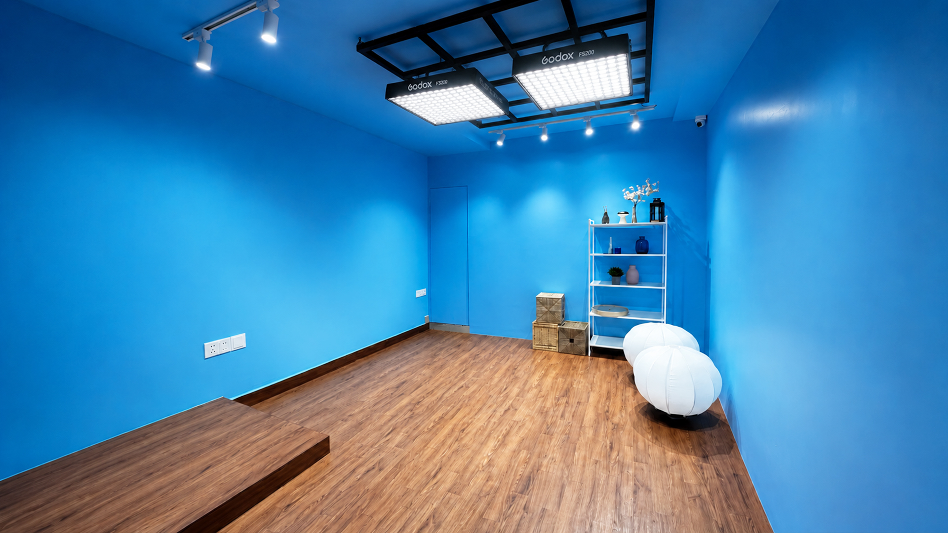 Blue-wall video production stage with professional lighting grid