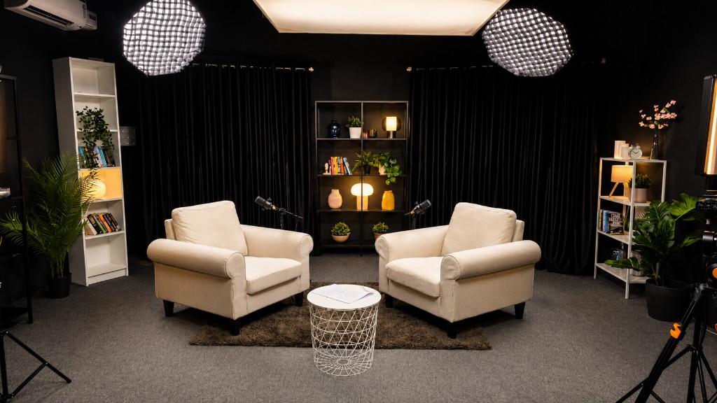 Dark premium podcast studio with cream armchairs, black drapes, overhead softboxes, and professional microphones at Winterfox Studios