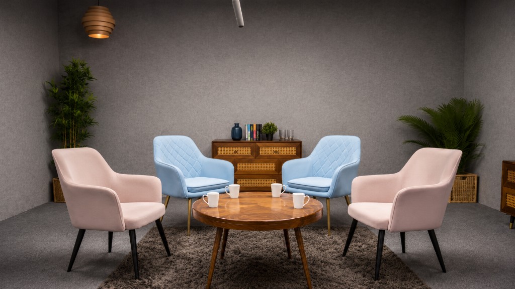 Four seater podcast studio with pink and blue armchairs, round wood table, and sideboard backdrop at Winterfox Studios