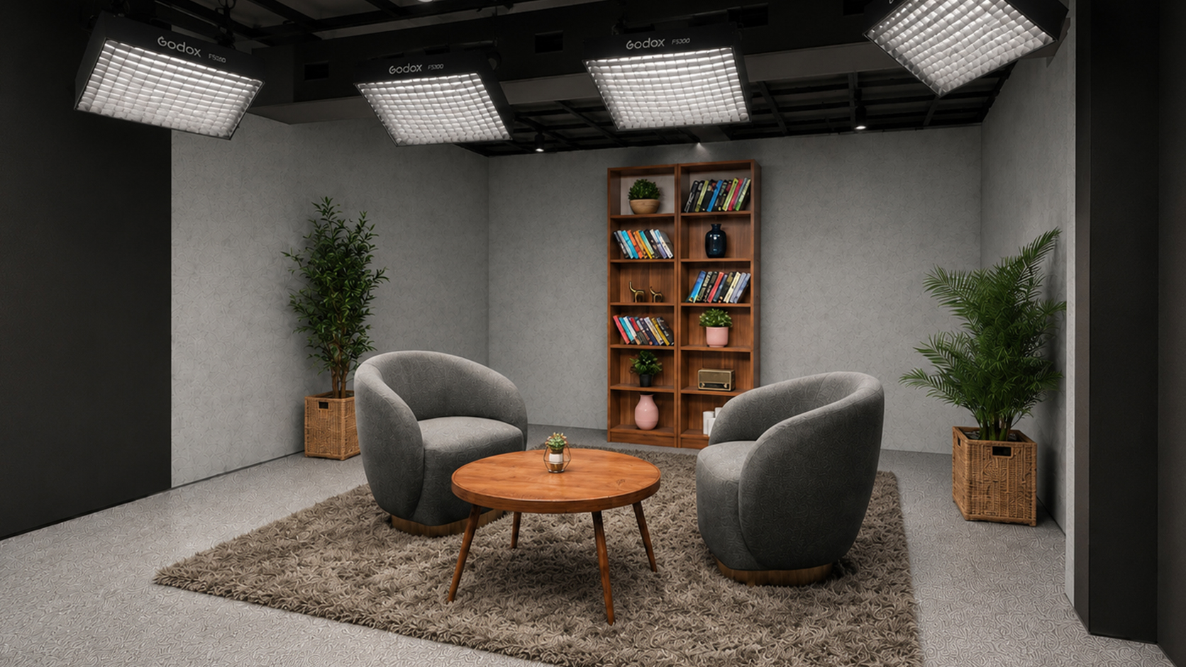 Grey podcast studio with facing armchairs and overhead lighting at Winterfox Studios