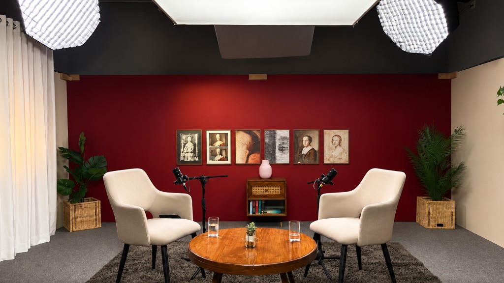 Red-wall podcast interview studio with dual seating and professional microphones at Winterfox Studios